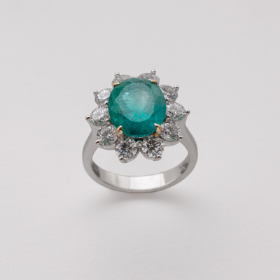 Sortija roset&oacute;n en oro blanco con esmeralda colombiana talla oval orlada por diamantes talla brillante.