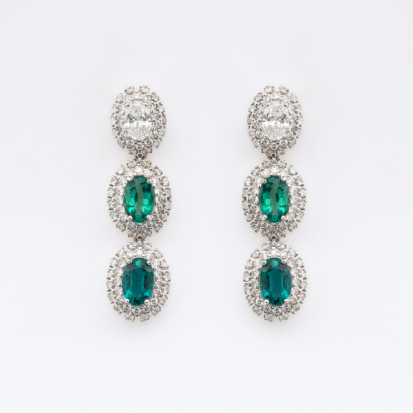 Pendientes largos en oro blanco con tres rosetones de diamante y esmeraldas (Colombia) talla oval orlados por diamantes talla brillante.