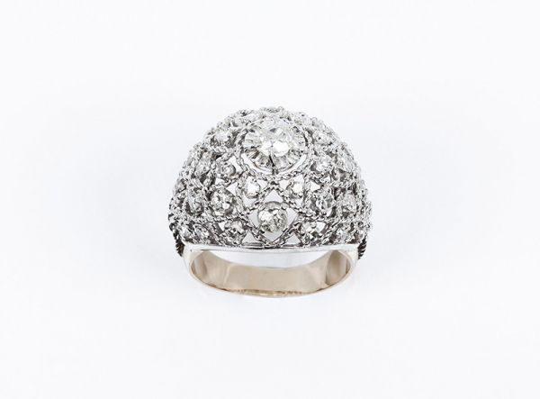 Sortija vintage en sólida montura de oro blanco y amarillo, diseño calado 'bombé', con un limpio y blanco diamante talla antigua 'cojín' en garras de ilusión sobre motivo en red de cordoncillo, cuajada de blancos diamantes talla 8/8, en garras