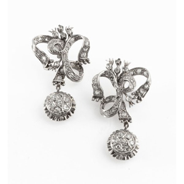 Pendientes largos en oro blanco en forma de lazo cuajado de diamantes y colgante con orla de 7 diamantes talla brillante cada uno con un peso total de 0,30 cts. aprox.