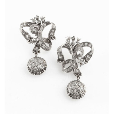 Pendientes largos en oro blanco en forma de lazo cuajado de diamantes y colgante con orla de 7 diamantes talla brillante cada uno con un peso total de 0,30 cts. aprox.