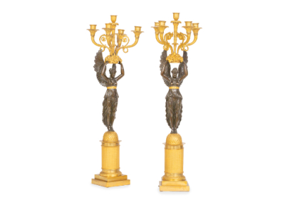 Pareja de candelabros imperio de bronce dorado y pavonado con cari&aacute;tides sustentando cinco brazos de luz. Trabajo franc&eacute;s, (1804-1814).