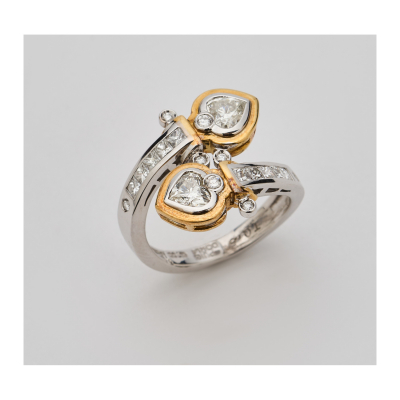 PUIG DORIA. Sortija diseño cruzado en oro bicolor con diamantes talla corazón, princesa y brillante. Firmada y numerada.