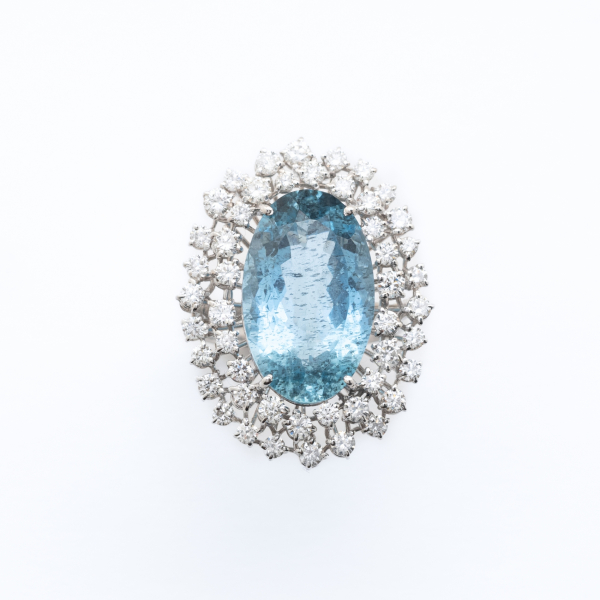 Gran sortija rosetón en oro blanco con aguamarina talla oval orlada por dos bandas de diamantes talla brillante 