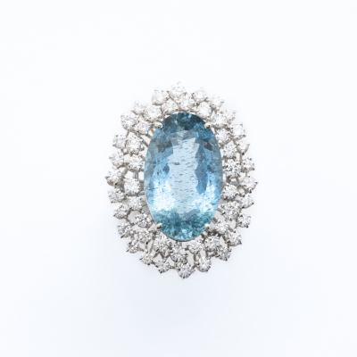 Gran sortija roset&oacute;n en oro blanco con aguamarina talla oval orlada por dos bandas de diamantes talla brillante 