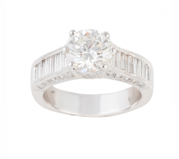 Sortija con brillante central de 2,01 ct con diamantes talla baguette en los brazos de la montura.   En oro blanco de 18 K.