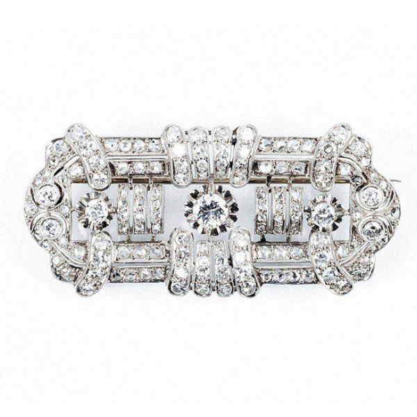 Placa-alfiler 'decó' en platino u oro blanco, con motivo geométrico calado, cuajado de limpios y blancos diamantitos