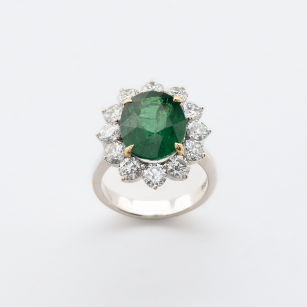 Sortija rosetón en oro blanco con tsavorita talla oval orlada por diamantes talla brillante.