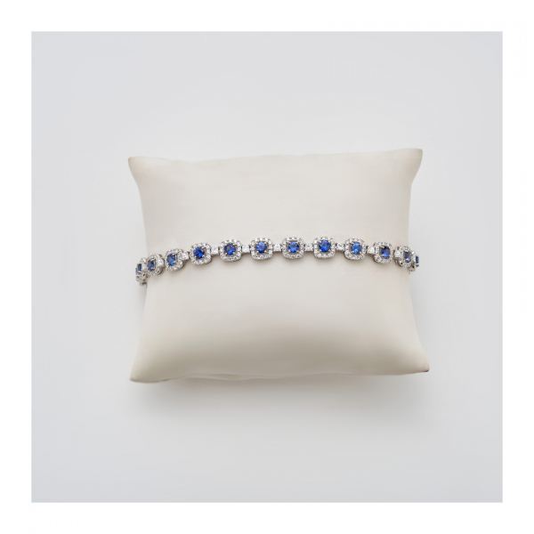 Pulsera en oro blanco con rosetones de zafiro azul talla redonda orlado por diamantes talla brillante y alternados por diamantes talla princesa.