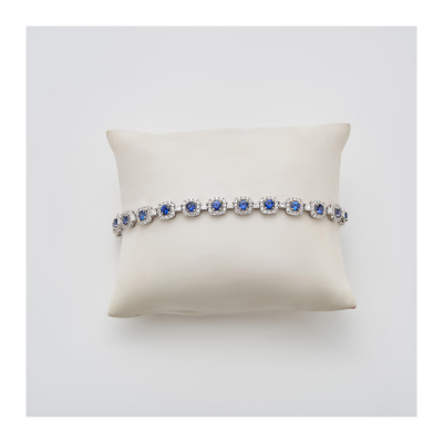 Pulsera en oro blanco con rosetones de zafiro azul talla redonda orlado por diamantes talla brillante y alternados por diamantes talla princesa.