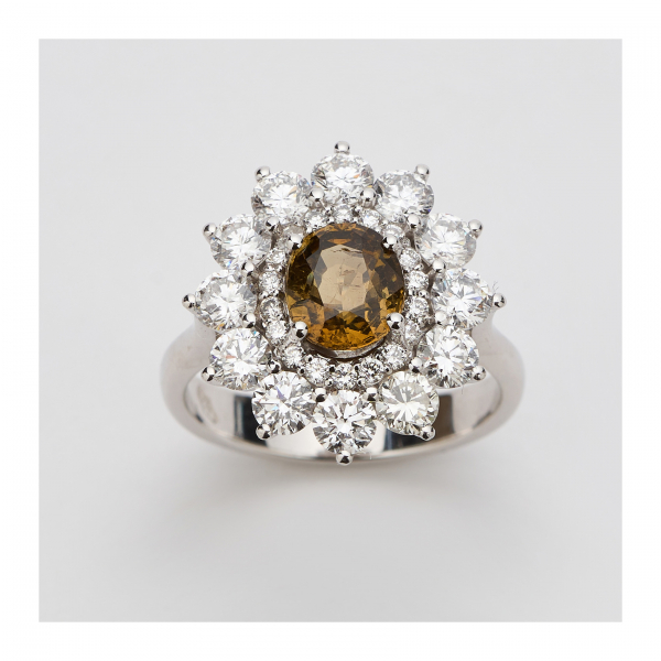 Sortija rosetón en oro blanco con alejandrita talla oval y doble orla de diamantes talla brillante engastados en garras.