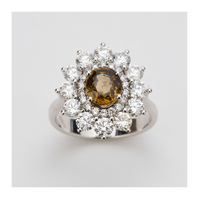 Sortija rosetón en oro blanco con alejandrita talla oval y doble orla de diamantes talla brillante engastados en garras.