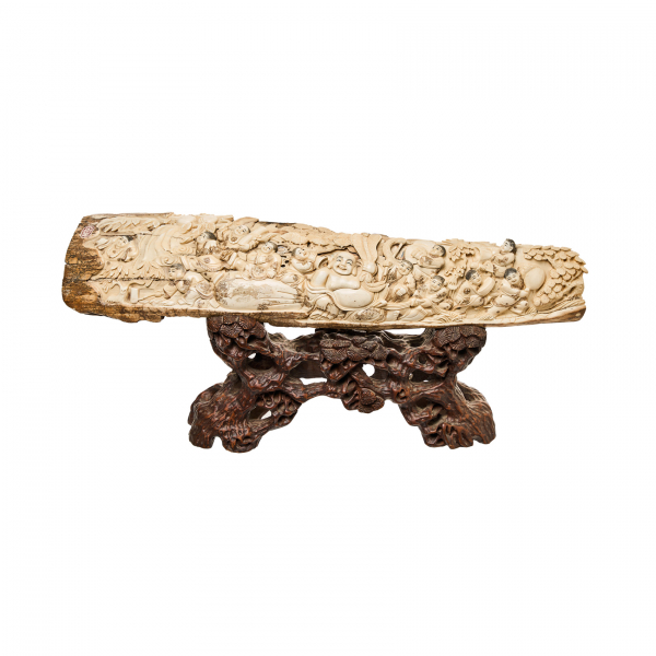 Relieve chino en marfil de mamut tallado con representación de Buda sobre peana en madera tallada con decoraciones florales, ppios. del s.XX.