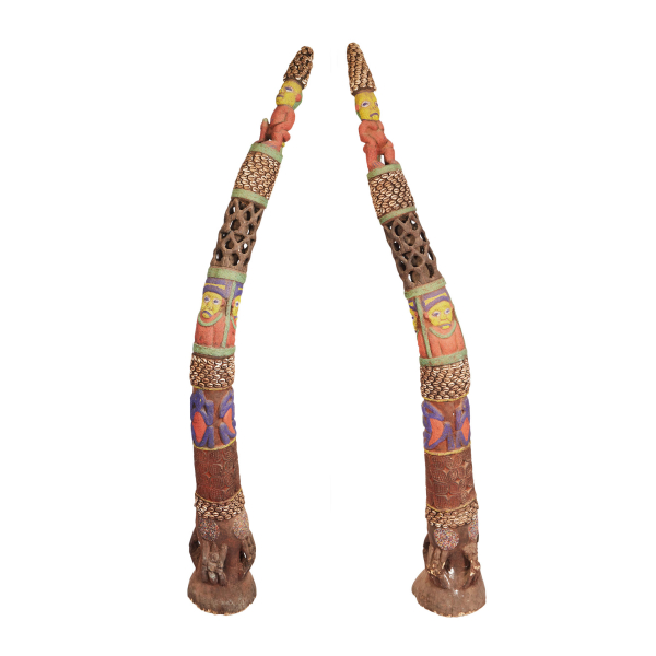 Pareja de colmillos en madera tallada con aplicaciones de «beats» de colores y conchas. Camerún, reproducción de mediados del s.XX.