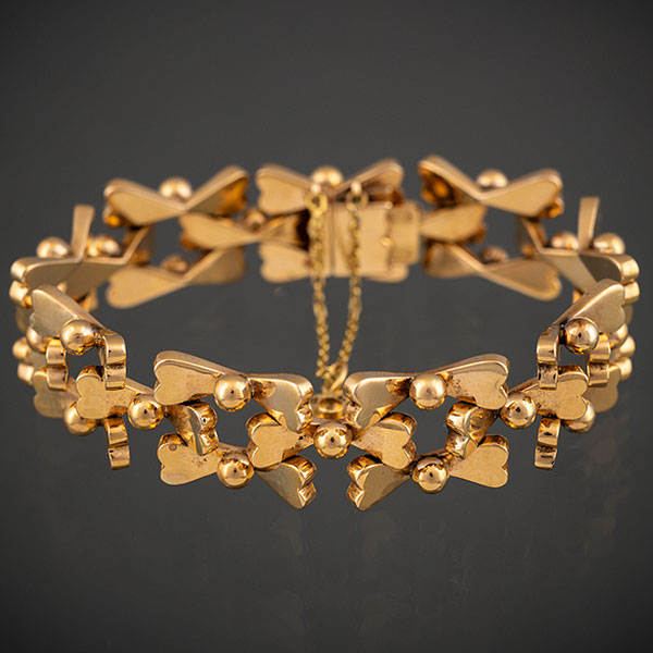 Pulsera ancha articulada de elementos calados en oro amarillo de 18 kt.