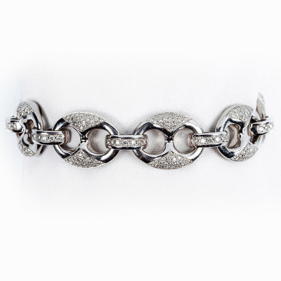 Brazalete de alta joyería en sólida montura de oro blanco, formada por grandes eslabones de calabrote con las vistas cuajadas de limpios y blancos diamantitos, talla brillante