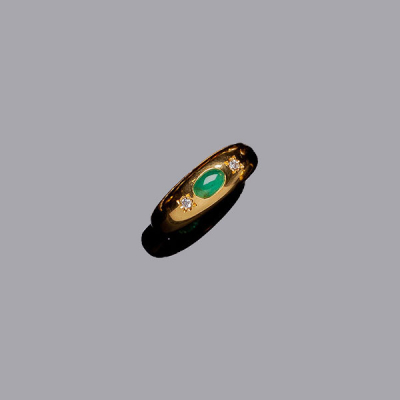 Anillo en oro amarillo, con esmeralda oval en cabuchón, y dos diamantitos a los lados. 2 dtes: 0.04 ct aprox.