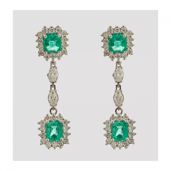 Pendientes largos en oro blanco con dos rosetones de esmeraldas talla octogonal orladas por diamantes talla brillante y unidos entre sí por pareja de diamantes talla navette.