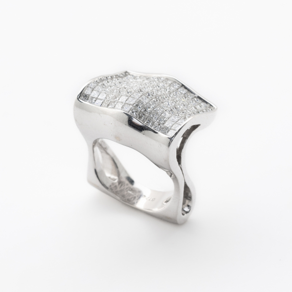 Sortija en oro blanco con frente rectangular ondulado cuajado de diamantes talla princesa engastados en invisible.