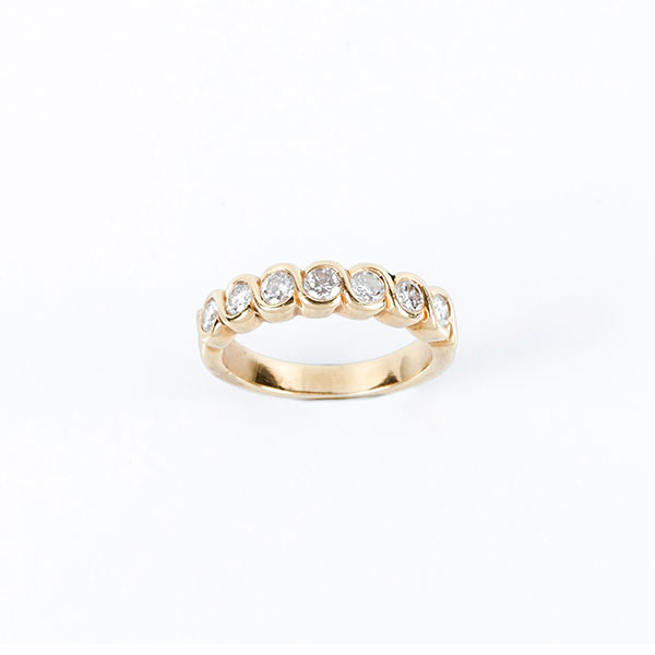 Anillo septillo en sólida montura de oro amarillo 18 K, con frente decorado en fila de limpios y blancos diamantes talla brillante, en chatón