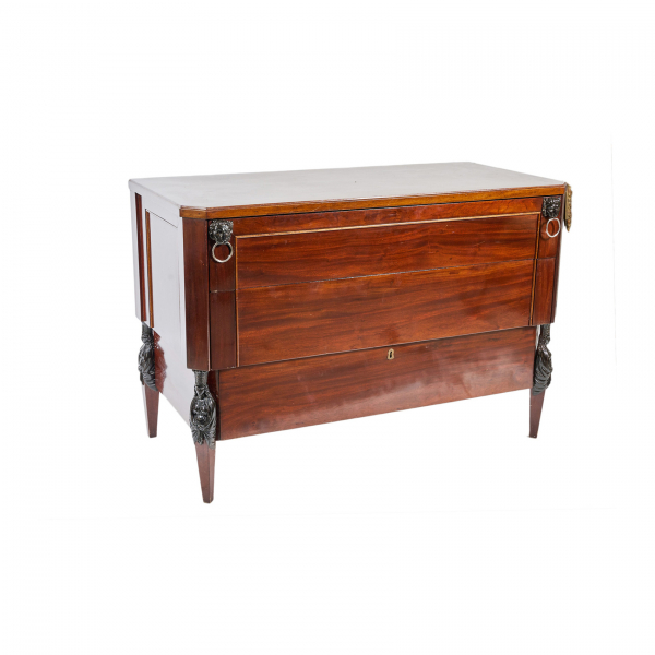 Cómoda estilo Imperio en madera de caoba con decoración de mascarones en forma de león y cariádites tallados en los ángulos, fles. del s.XIX-ppios. del s.XX.