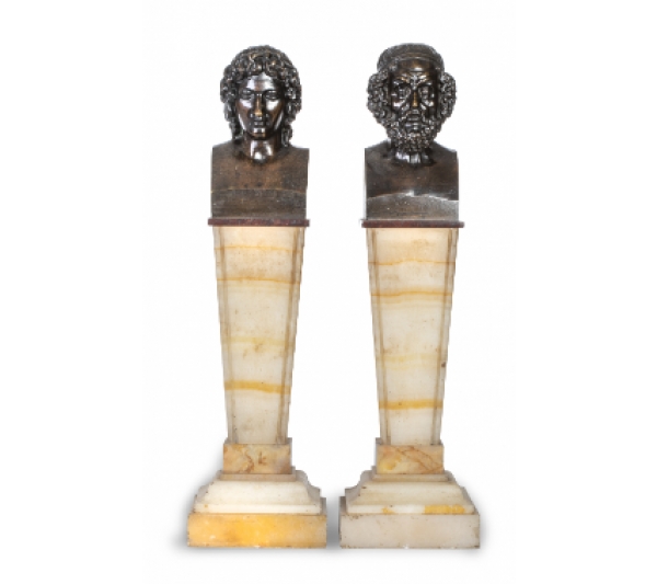 Pareja de bustos de bronce sobre peanas de mármol con forma de estípite.