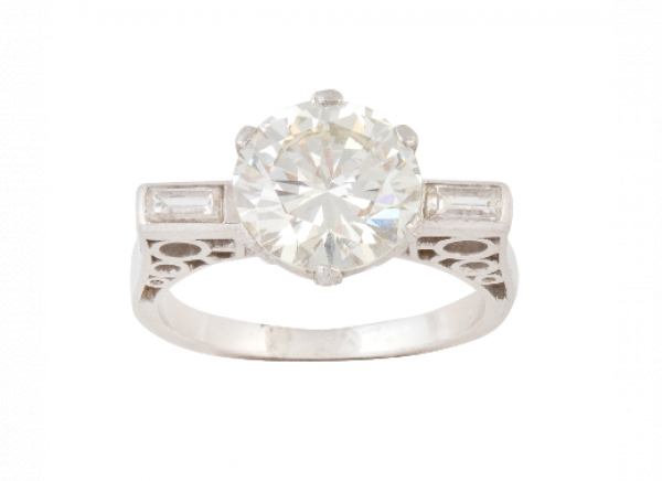 Sortija solitario con bte de 3,38 ct aprox flanqueado por brillante talla baguette. En oro blanco de 18K.