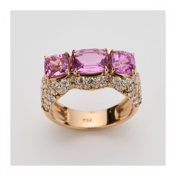 Sortija en oro rosa con tres zafiros rosas talla cojín y diamantes talla brillante. 