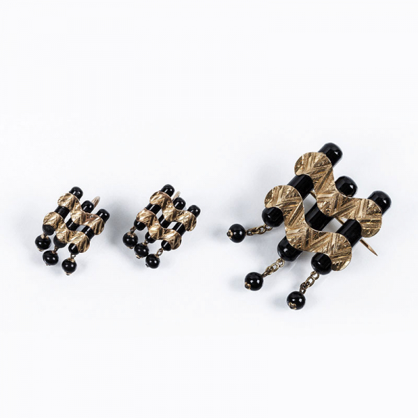 Original conjunto antiguo de alfiler y pendientes, estilo &#039;decó&#039;, de formas ondulantes, que recuerda las olas del mar. Realizado en oro amarillo 18 K y piezas de ónix negro.