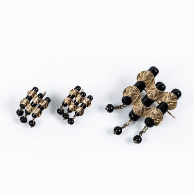 Original conjunto antiguo de alfiler y pendientes, estilo &#039;decó&#039;, de formas ondulantes, que recuerda las olas del mar. Realizado en oro amarillo 18 K y piezas de ónix negro.
