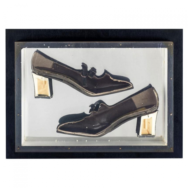 Arman. "Construction of shoes (1965)". Zapato de tac&oacute;n (coupe) sobre panel de madera negra con cubierta de plexigl&aacute;s.