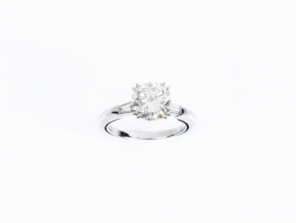 Un limpio y blanco diamante talla brillante de 2.53 ct, montado en anillo de oro blanco con diamantes trapecio en los hombros. Se acompaña de certificado del año 1987 del International Gemmological Institute (IGI, Antwerp).