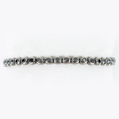 Pulsera riviere SUAREZ en sólida montura de oro blanco 18 K, pavonado, con fila articulada de diamantes negros 