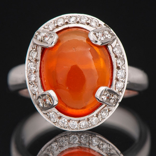 Sortija en oro blanco de 18 kt con ópalo naranja orlado de brillantes.