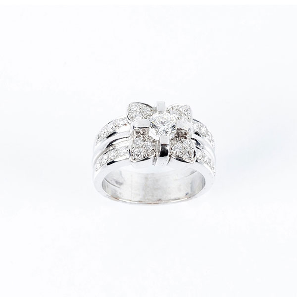 Sortija de alta joyería en sólida montura de oro blanco 18 K con motivo de flor en pavé de limpios y blancos diamantes, talla brillante con brillante central
