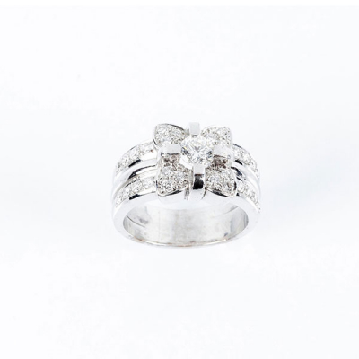 Sortija de alta joyería en sólida montura de oro blanco 18 K con motivo de flor en pavé de limpios y blancos diamantes, talla brillante con brillante central