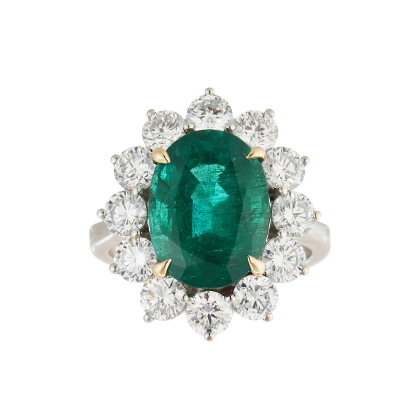 Sortija rosetón en oro blanco con magnífica esmeralda de Zambia orlada por diamantes talla brillante engastados en garras.