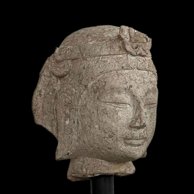 Cabeza del Bodhisattva Avalokitésvara “Kwan Yin” de belleza juvenil.   Arenisca gris. Dinastía Qi del Norte 550 a 577 , “Bei Qi”.
