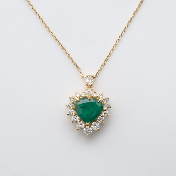 Gargantilla en oro con esmeralda (Zambia) talla coraz&oacute;n orlada por diamantes talla brillante y coronada por diamantes tallas perilla y oval.