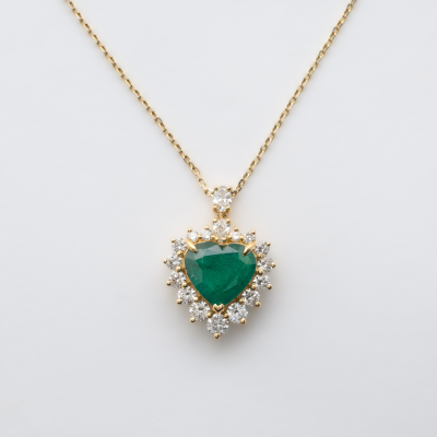 Gargantilla en oro con esmeralda (Zambia) talla coraz&oacute;n orlada por diamantes talla brillante y coronada por diamantes tallas perilla y oval.