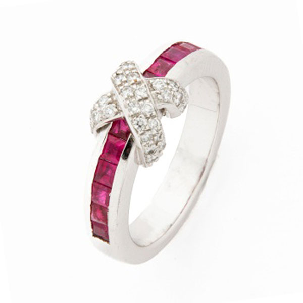 Sortija en oro blanco con fila de rubíes y cruz cuajada de diamantes talla brillante.