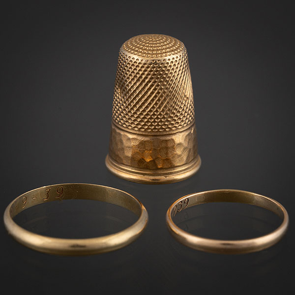 Conjunto de dedal y dos alianzas en oro amarillo de 18 kt.
