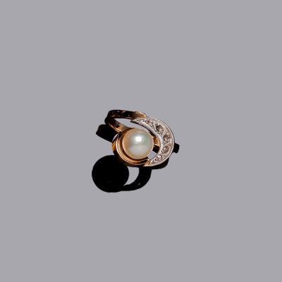 Sortija vintage en montura de oro amarillo, con centro calado, con perla cultivada de 7 mm, y motivo en media luna, con fila de diamantitos sobre vistas grafiladas de oro blanco.
