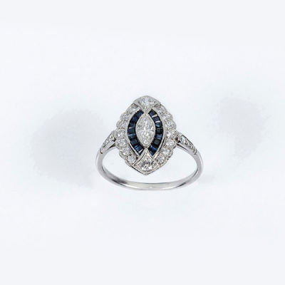 Delicada sortija estilo art-dec&oacute; en platino, con un limpio y blanco diamante talla marquisse, zafiritos azules y limpios y blancos diamantes talla brillante 