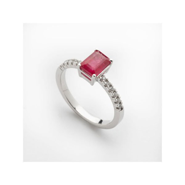 Sortija en oro blanco con rubí central y diamantes talla brillante a cada lado con un peso total de 0,10 cts. aprox.