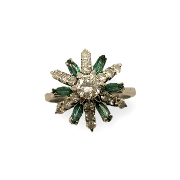 Sortija en oro blanco de 18k con un diamante central talla brillante y esmeraldas talla marquesa.