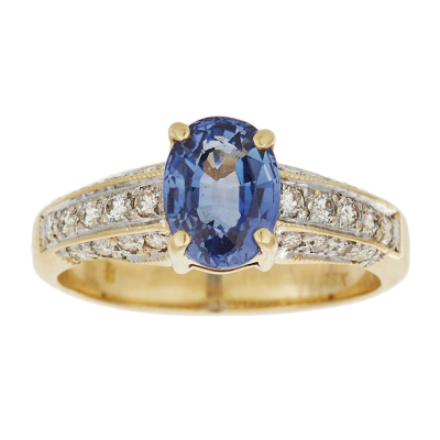 Sortija en oro bicolor con zafiro azul talla oval y brazos de diamantes talla brillante.