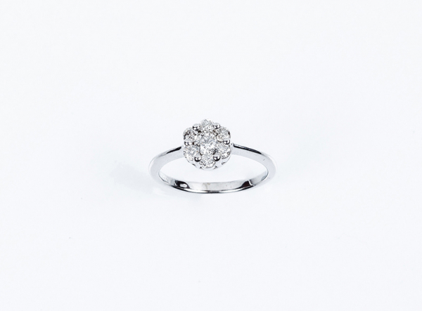 Anillo en oro blanco con centro en rosetón de limpios y blancos diamantes talla brillante.