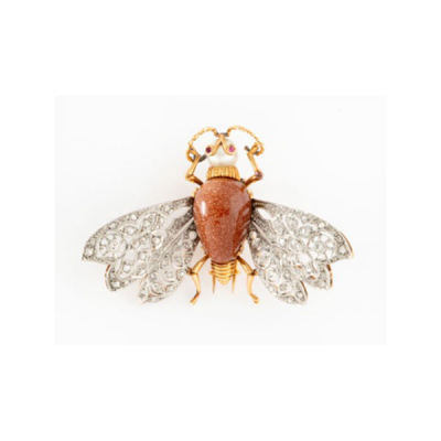 Broche representando mosca en oro amarillo y alas en oro blanco con cuerpo en piedra venturina, perla cultivada representando cabeza, y rubís en los ojos, alas con decoración de flores con 2 diamantes talla brillante y cuajado de diamantes.