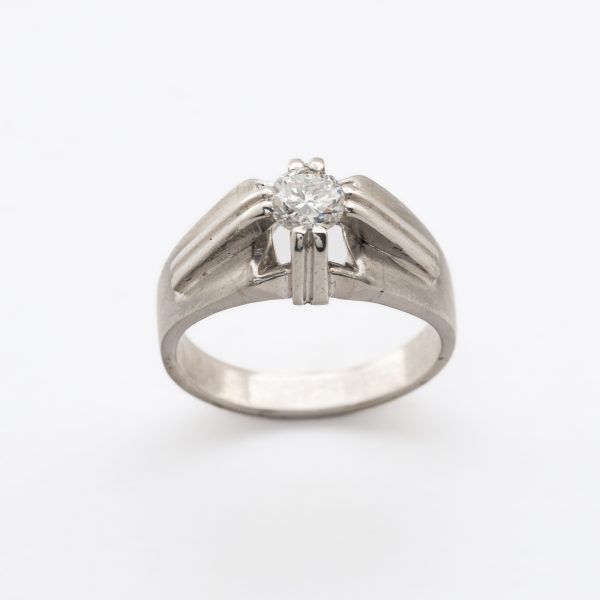 Sortija solitario de caballero en oro blanco satinado con diamante talla brillante engastado en garras.